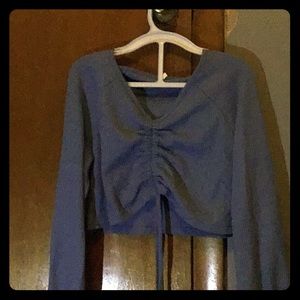 A blue cropped , long sleeve shirt